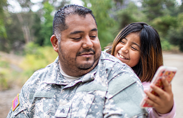 military dad and daughter smiling together