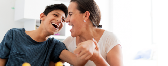 mom and special needs son smiling together