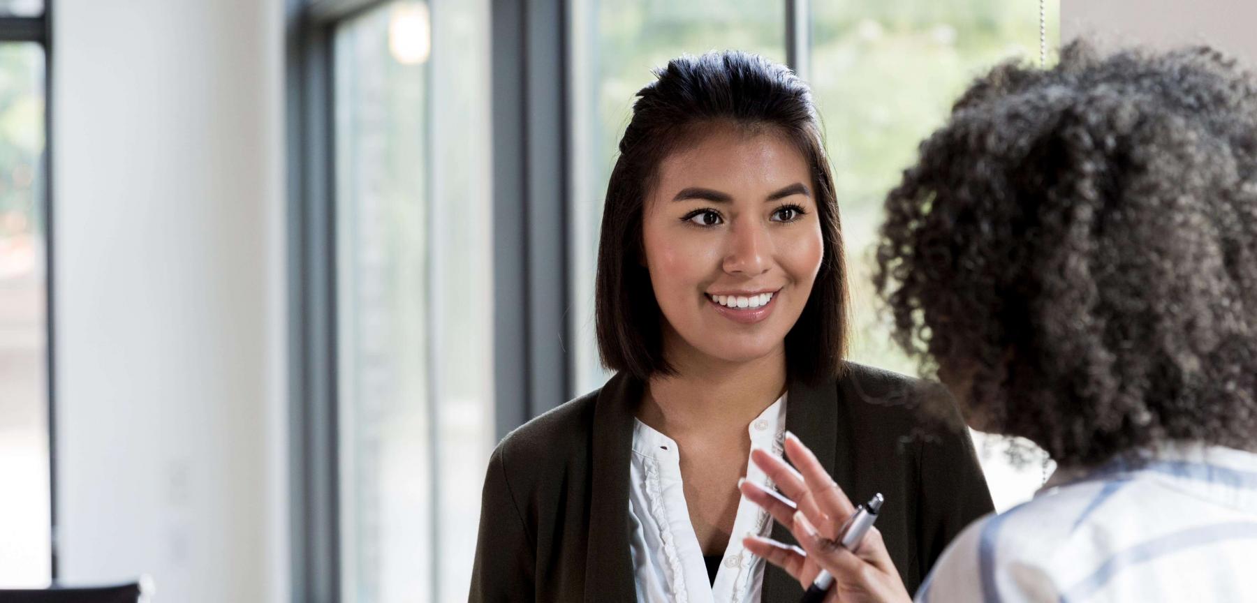 Two women conferring in office