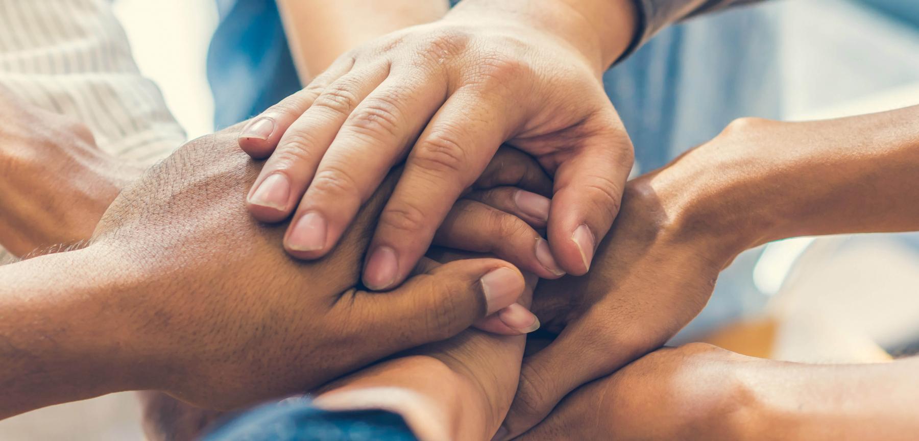 Group of people with their hands in the middle