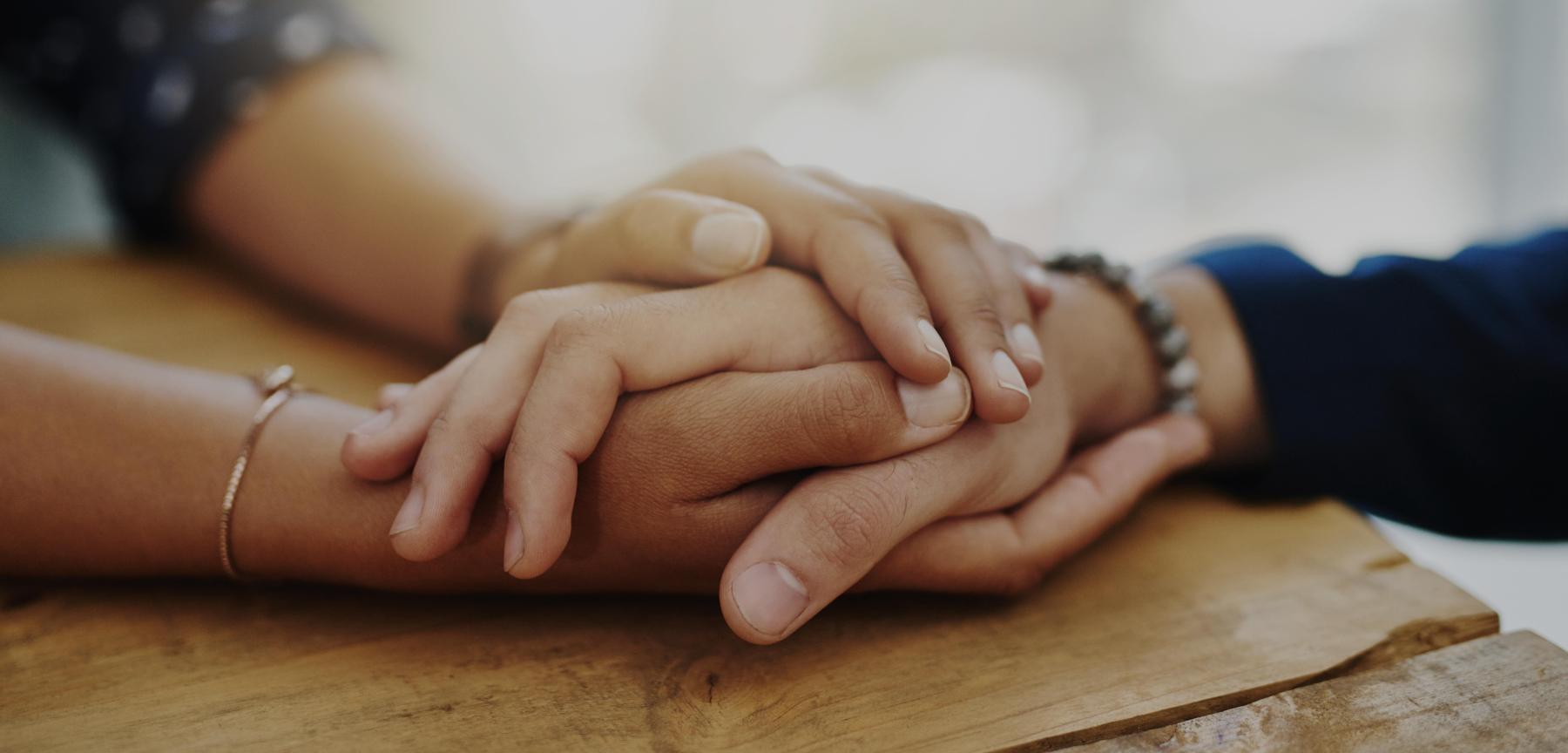 two people holding hands in comfort