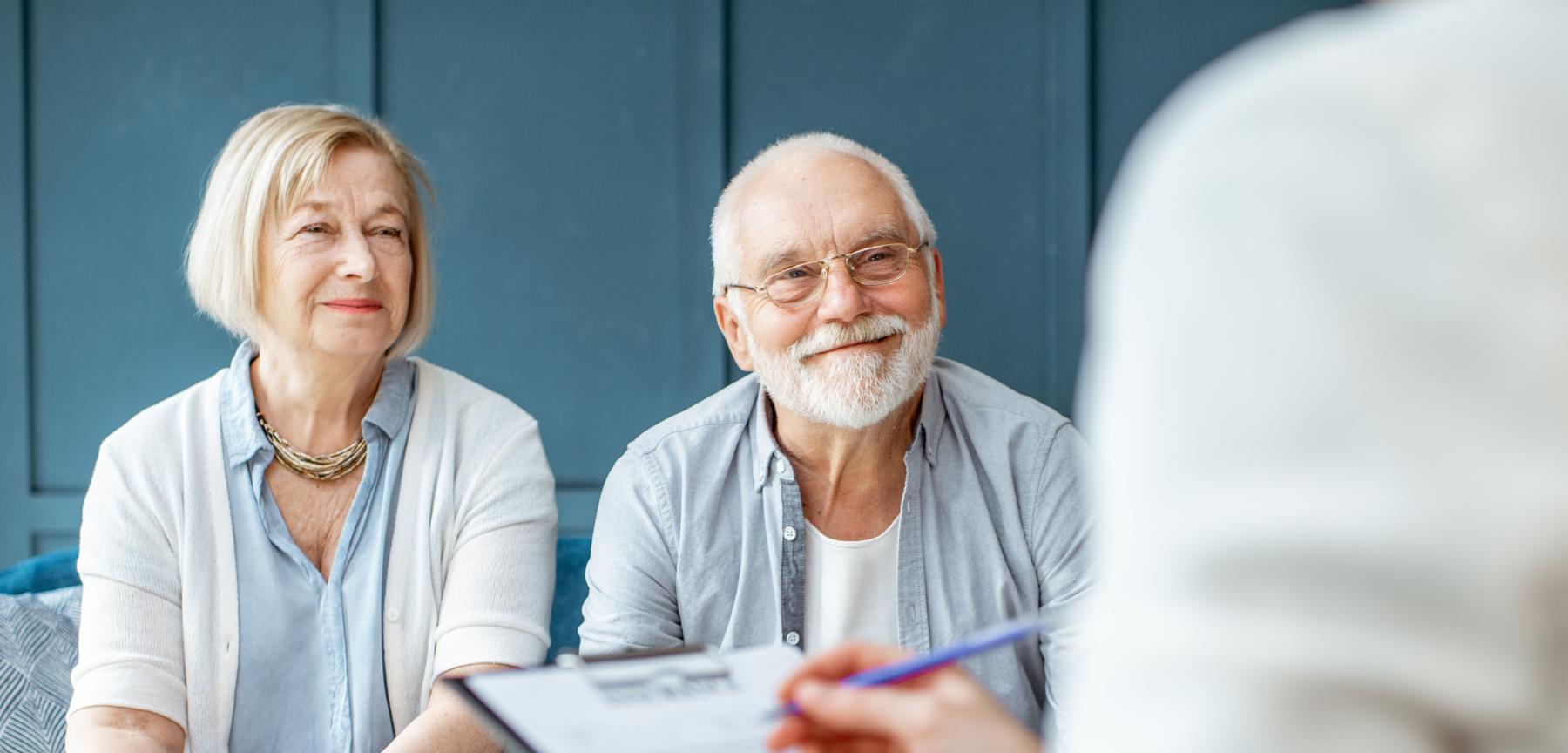 Couple sitting with trust officer looking at estate documents